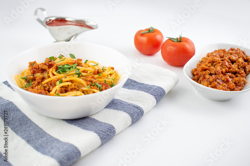 Spaghetti bolognese on a white plate. Italian cuisine concept, food ingredients. Flat lay. Top view