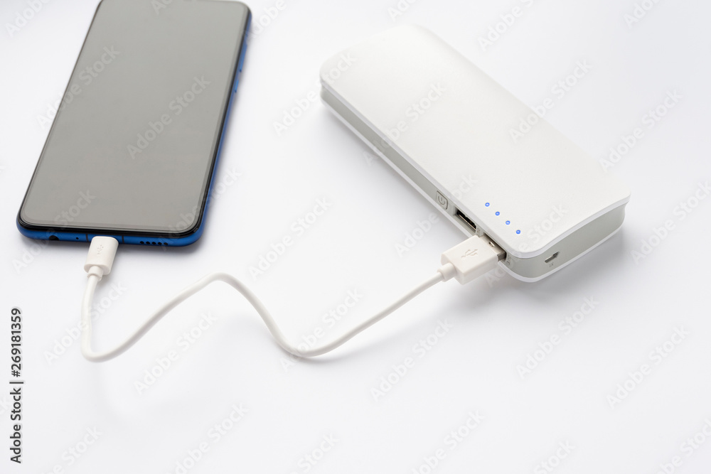 The smartphone is charging from a portable charger. Phone charging. The smartphone is charging from a portable charger. Phone charging.