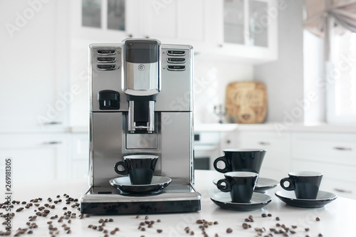 Photo Coffee machine with cups for espresso on the kitchen table
