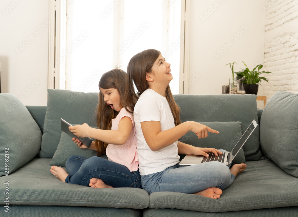 Two pretty sisters having fun together playing and surfing on th Two pretty sisters having fun together playing and surfing on th