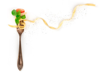 Italian pasta. An overhead photo of a vintage fork with pappardelle, basil, cheese, tomato, and pepper, on a white background with a place for text