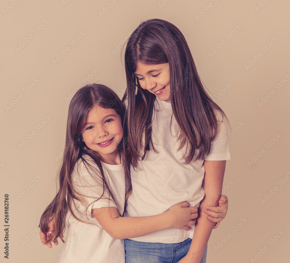two cute sisters playing together having fun posing and modeling two cute sisters playing together having fun posing and modeling