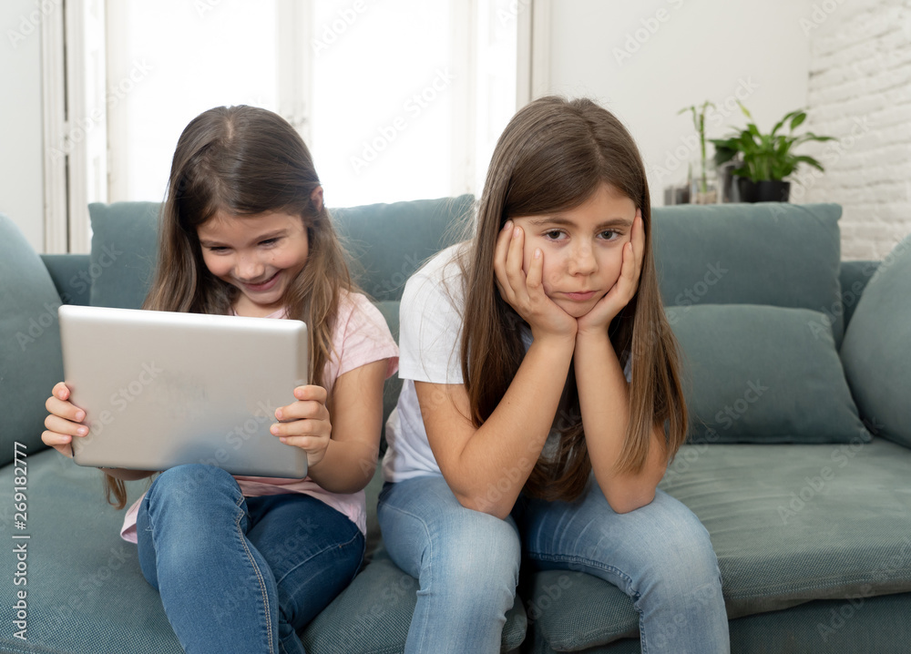 Young little girl using laptop ignoring her angry sad lonely old Young little girl using laptop ignoring her angry sad lonely old