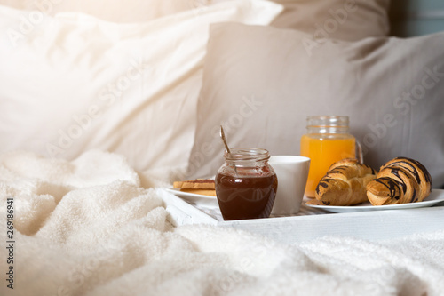 Breakfast in bed, a tray of coffee, croissants, jam, flowers. Honeymoon. Early morning at the hotel. View from above.