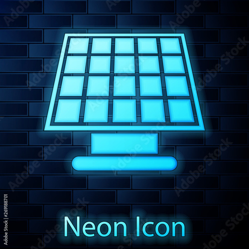 Glowing neon Solar energy panel icon isolated on brick wall background. Vector Illustration
