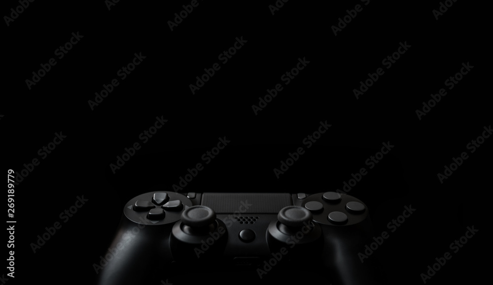 Modern black gamepad on a dark background. Game concept with copy space for text or design. Modern black gamepad on a dark background. Game concept with copy space for text or design.