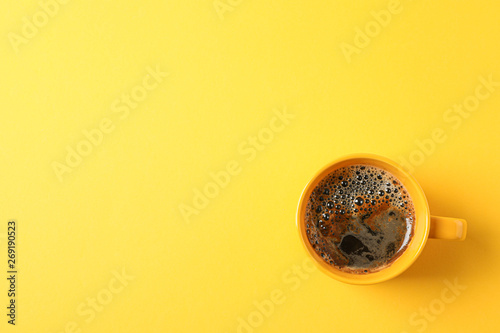 Cup of coffee with frothy foam on color background, space for text and top view. Coffee time accessories © Atlas