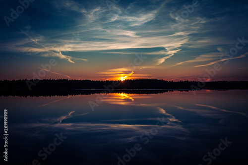The forest lake at sunset, with reflection of sky and forest on a water smooth surface, Russia, Mari El © Evgesha