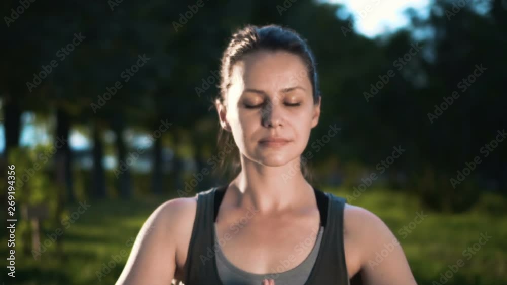 Beautiful woman with eyes closed focused and concentrated while practicing yoga in lotus pose holding her hands in front of her Beautiful woman with eyes closed focused and concentrated while practicing yoga in lotus pose holding her hands in front of her