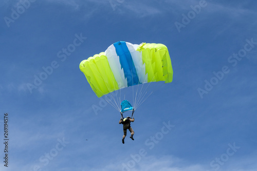 Skydiving. A parachute is in the sky.