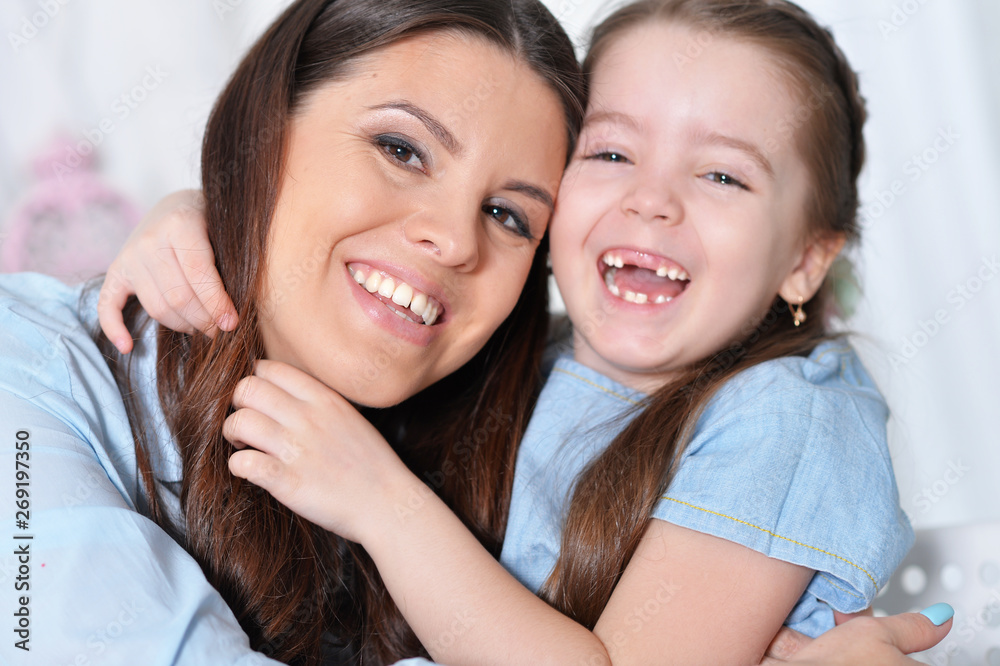 Close up portrait of little girl with mother hugging Close up portrait of little girl with mother hugging