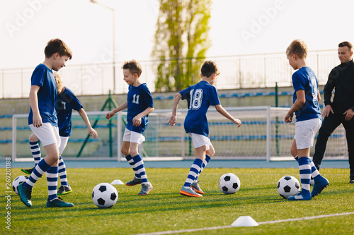 Young Boys in Sports Club on Soccer Football Training. Kids Enhance Soccer Skills on Natural Turf Grass Pitch. Football Practice Session for Children Youth Team of Professional School Soccer Club © matimix