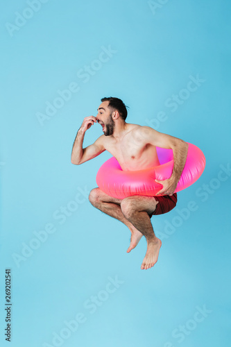 Billede på lærred Photo of attractive shirtless tourist man wearing rubber ring smiling while swim