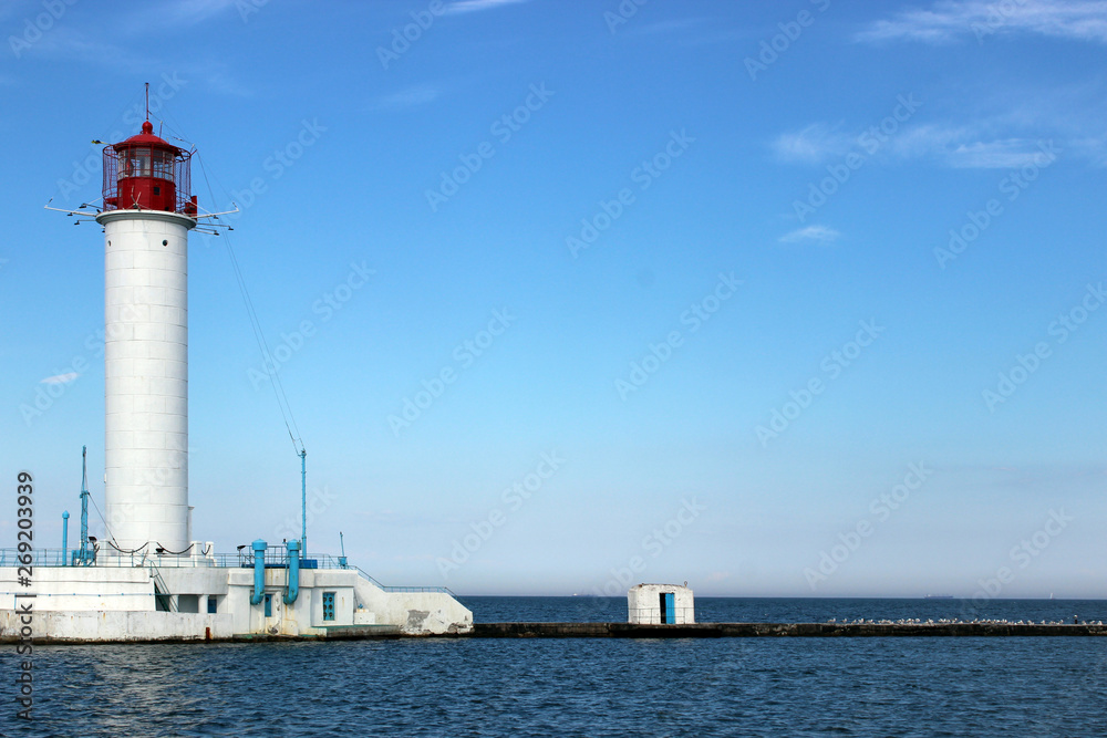 Lighthouse against the blue sky and sea