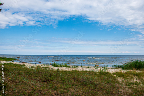 empty sea beach in summer with waves and broken clouds