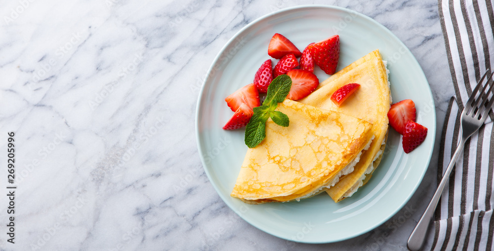 Crepes, thin pancakes with cream cheese, ricotta and fresh strawberries. Marble background. Top view. Copy space. Crepes, thin pancakes with cream cheese, ricotta and fresh strawberries. Marble background. Top view. Copy space.