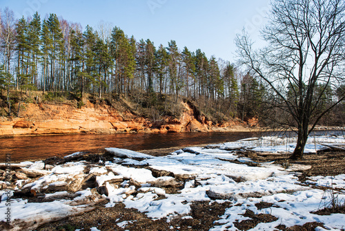 natural sand stone cliffs on the shore of the river in forest