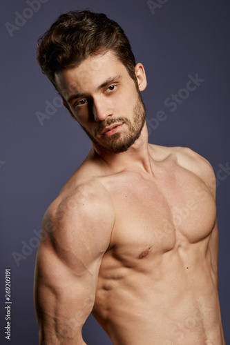 gorgeous man with showing his nude strong body. close up cropped photo. studio shot.