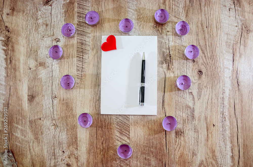 notebook with pen and red heart on wooden background. View from above. notebook with pen and red heart on wooden background. View from above.
