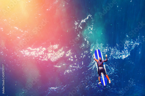 Surfer rows up to catch cre...