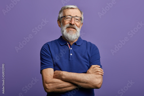 happy cheerful man in stylish blue T-shirt with arm crossed rejoicing at his retirement. health, beauty concept. free time, spare time