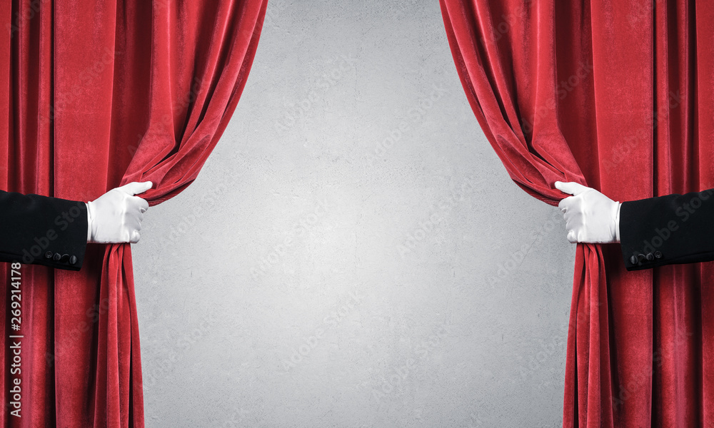 Concrete wall behind drapery curtain and hand opening it