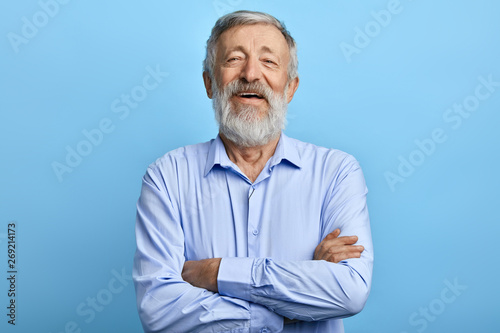 friendly handsome man standing with crossed arms, laughing at something, looking at the camera. close up photo.happiness, feeling and emotion
