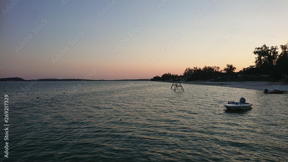 Naklejka premium Fishing boats on beach at sunset