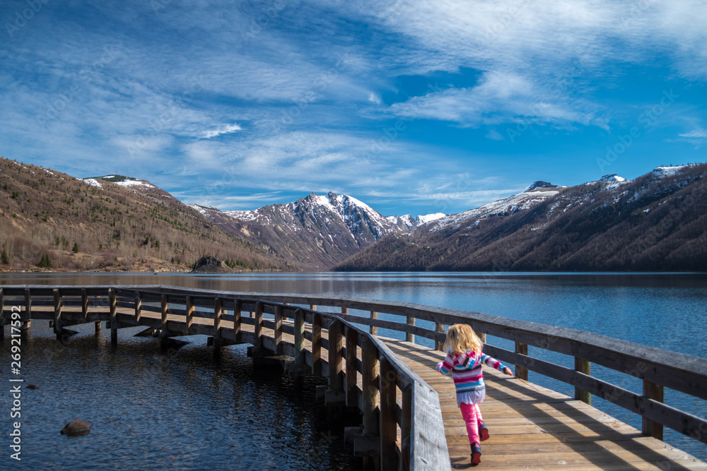 Little Girl Running on Walkway by a Lake