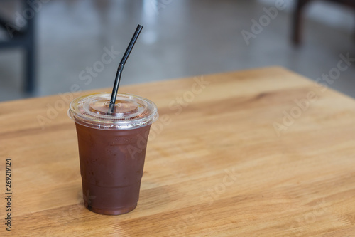 Iced Americano coffee in plastic glass.Indoor cafe.