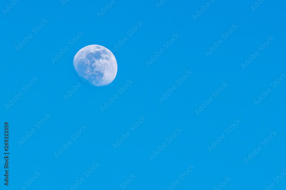Moon during the day, against a flawless beautiful blue sky, close-up Moon during the day, against a flawless beautiful blue sky, close-up
