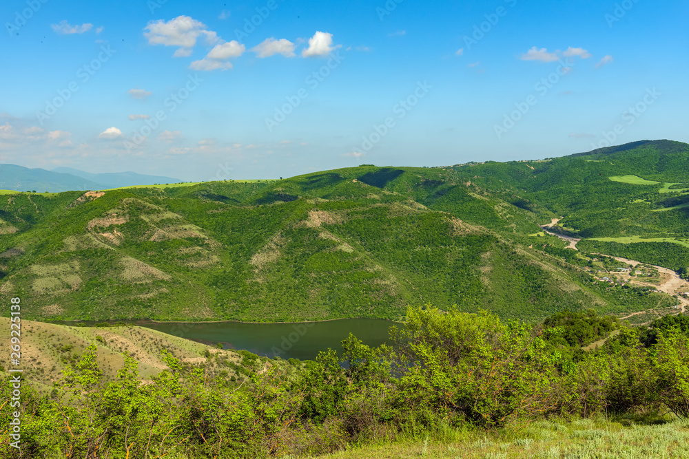 Landscape of mountains covered with green forest and blue sky with clouds Landscape of mountains covered with green forest and blue sky with clouds