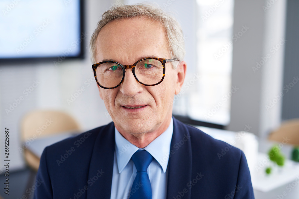 Waist up of confident businessman in the office Waist up of confident businessman in the office