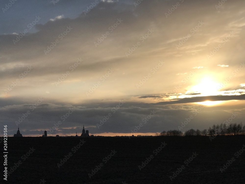 Naklejka premium sunset over the green field