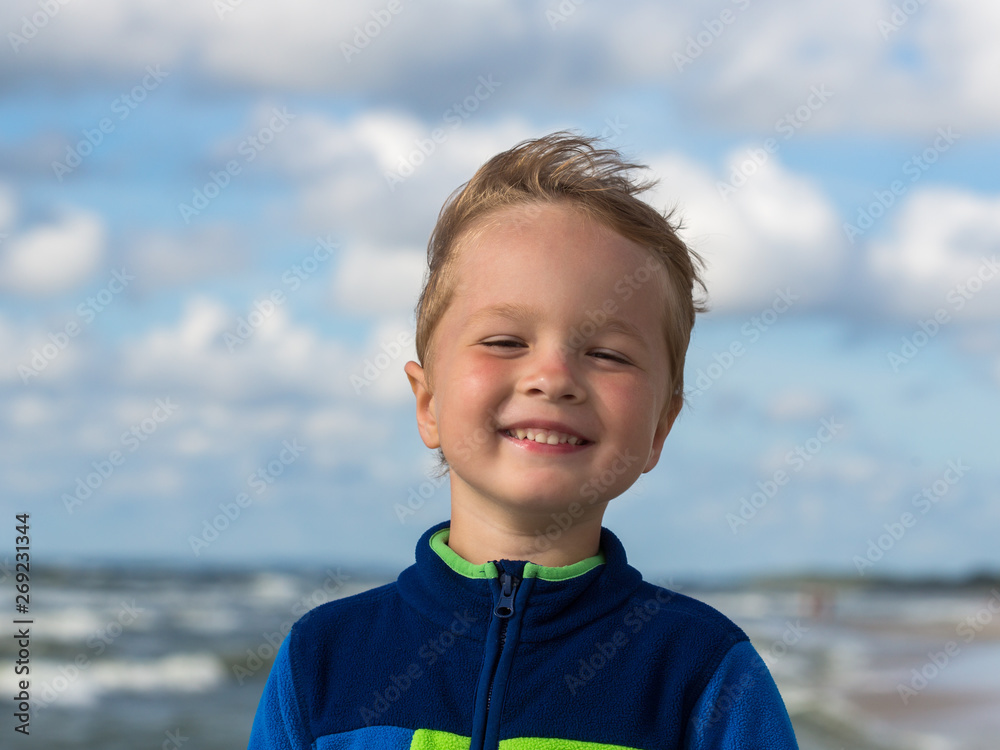 portrait of a small smiling boy near the sea portrait of a small smiling boy near the sea