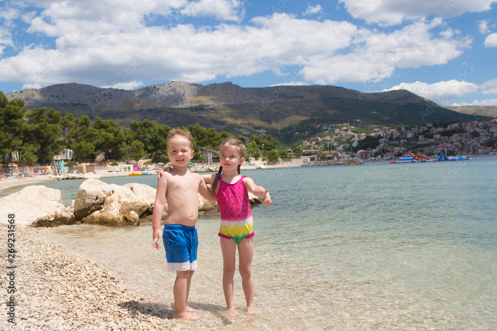 Happy children embrace each other on the beach, Croatia, Split