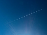 scia di un aereo nel cielo con raggi solari