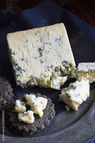 Mature English Stilton cheese with charcoal crackers with low key light