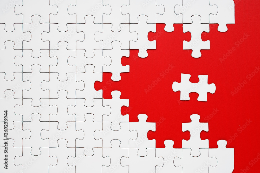 White puzzle pieces on a red background separated White puzzle pieces on a red background separated