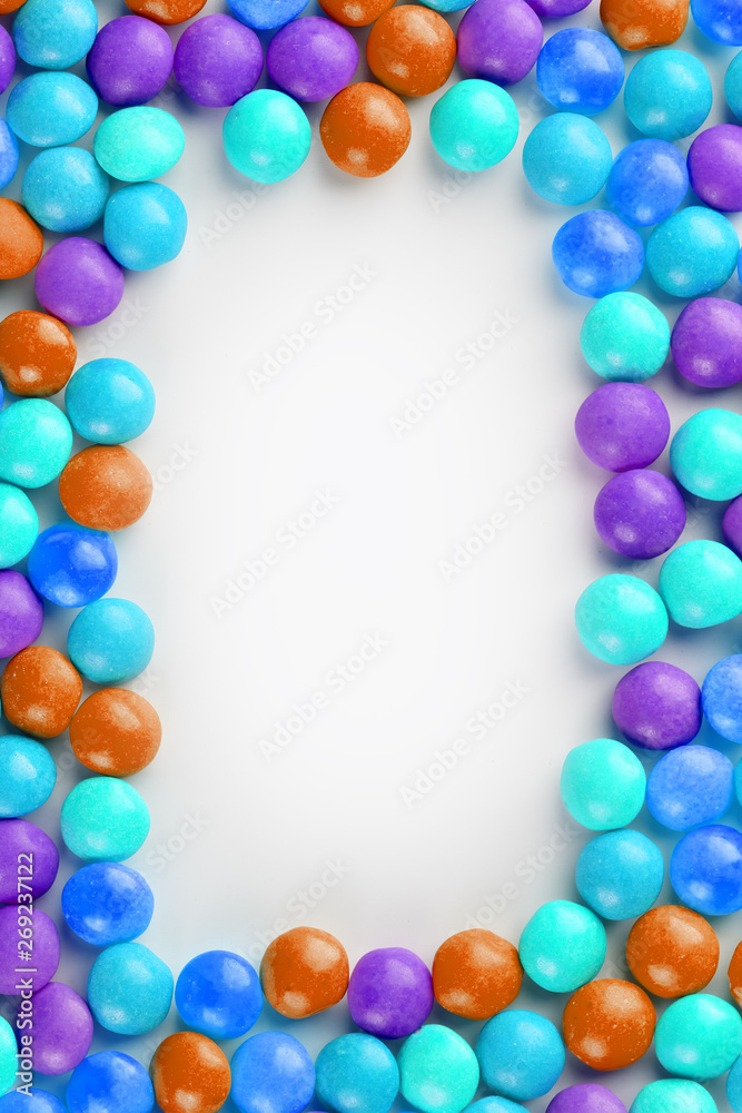 Frame of multi-colored candies close up. Rainbow colored dragee multicolored glaze on a white background Frame of multi-colored candies close up. Rainbow colored dragee multicolored glaze on a white background