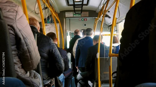 People in a public bus riding on street.