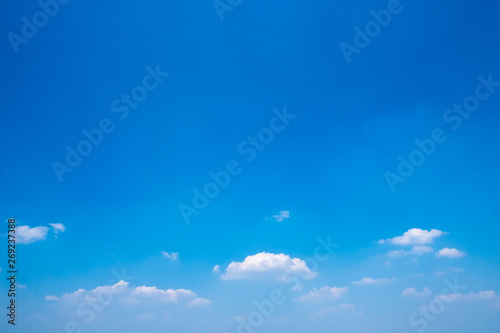 Beautiful clear blue sky with white fluffy clouds on a sunny day.