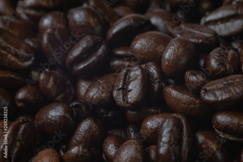 close up of pile roast coffee beans on wooden board