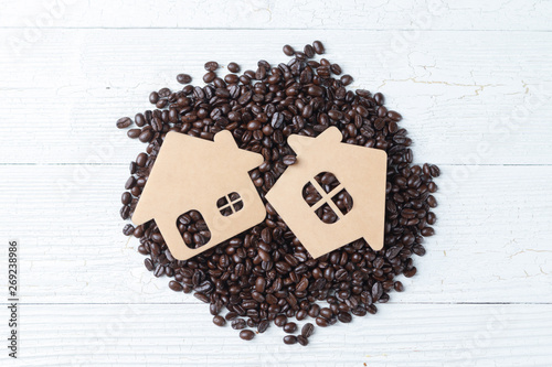 close up of pile roast coffee beans and small wooden home