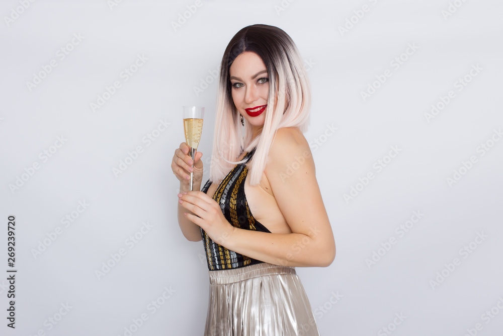 Blonde woman in black bodysuit and silver skirt holding glass of champagne Blonde woman in black bodysuit and silver skirt holding glass of champagne
