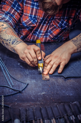 Artisan cutting out leather goods  photo