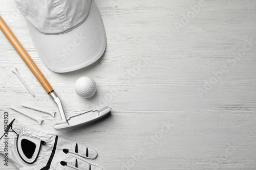 Flat lay composition with golf accessories and space for text on white wooden background photo