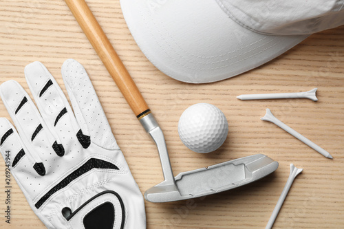 Flat lay composition with golf accessories on wooden background photo