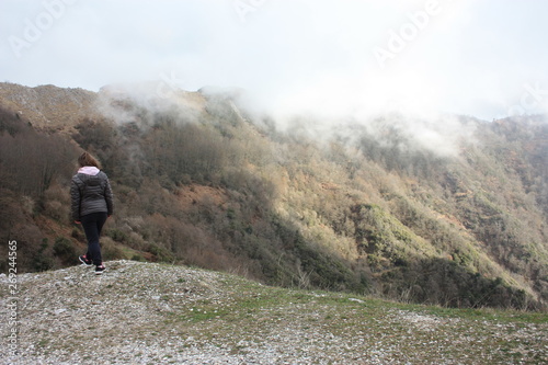 girl walks alone in the mist and fog along the paths of the Apuan Alps in Tuscany © Alessia