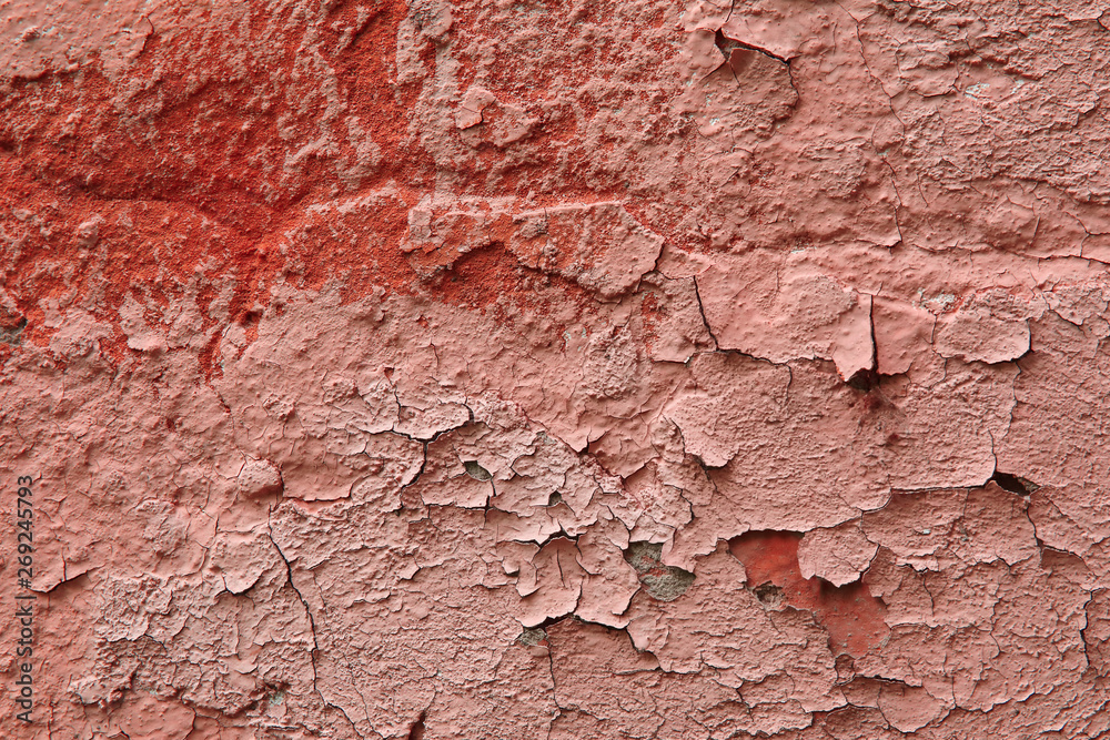 Fragment of an old exterior wall with cracked peeling plaster pink color Fragment of an old exterior wall with cracked peeling plaster pink color